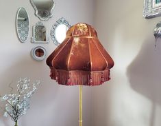 a lamp that is on top of a table next to a vase with flowers in it