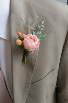 a man in a suit with a pink flower on his lapel