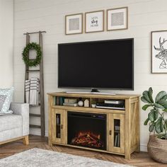 a living room with a fireplace and television on the entertainment center in front of it