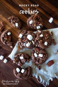 rocky road cookies with marshmallows and pecans on a napkin next to them