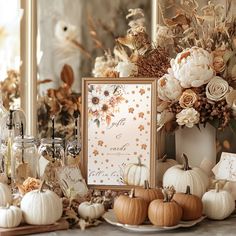 a table topped with lots of white pumpkins and other fall decorating items next to a mirror