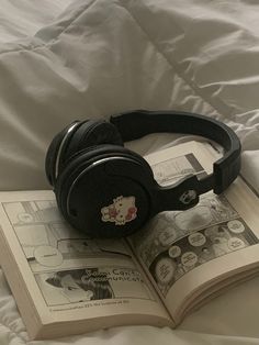 an open book with hello kitty headphones on top of it next to a pair of headphones