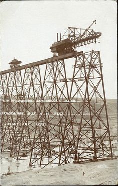 an old photo of a train going over a bridge