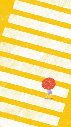 a woman with an umbrella walks across the street in front of yellow and white stripes