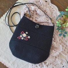 a black purse sitting on top of a white doily