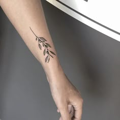 a woman's arm with a small tattoo on the left side of her arm