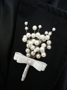 a white boutonniere with pearls on it