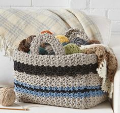 a crocheted bag sitting on top of a couch next to a ball of yarn