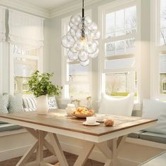 a dining room table with fruit on it in front of two windows and a bench