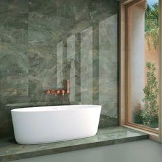 a bath tub sitting next to a window in a bathroom