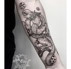 a black and white photo of a dragon tattoo on the right arm, with balls coming out of it