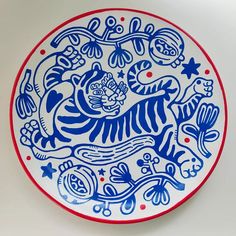 a blue and white plate with an image of a tiger in the middle of it