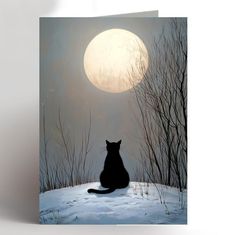 a black cat sitting in the snow under a full moon