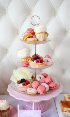 three tiered trays filled with cupcakes and pastries