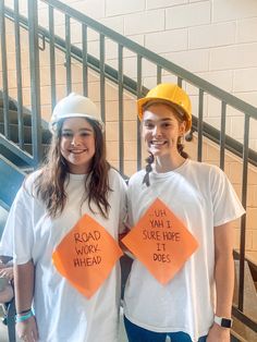 two girls wearing construction hats and t - shirts that read road work, work ahead