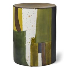 a green, yellow and white vase sitting on top of a table