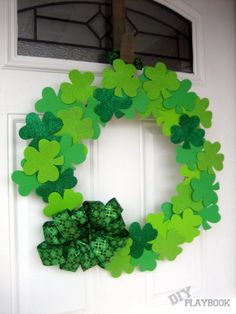 a wreath made out of green paper shamrocks on a door with the word st patrick's day written below it