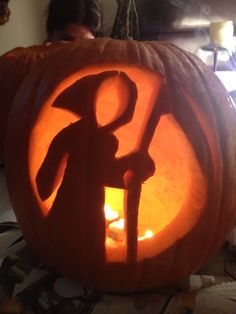 a carved pumpkin with an image of a person holding a hammer in it's center