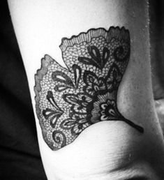 a black and white photo of a woman's arm with a tattoo on it