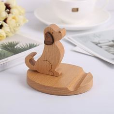 a small wooden animal figurine sitting on top of a table next to flowers