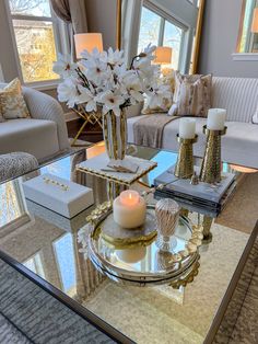 a living room filled with furniture and a glass table topped with a white flower centerpiece