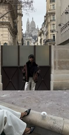 a woman sitting on the ground in front of a building