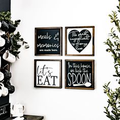 three black and white signs hanging on the wall next to a potted green plant