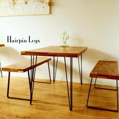 three wooden tables with hairpin legs and a vase on the wall behind one table