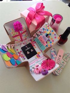 an assortment of items are displayed on a white table with pink ribbons and bows,