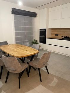 a kitchen with a table and chairs next to an oven in the middle of it