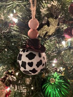 a cow print ornament hanging from a christmas tree