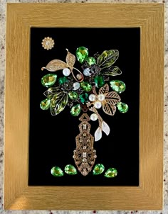 a gold frame with some green and white flowers on the front, and pearls in the back