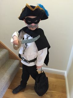 a little boy dressed up as a pirate with a mask and eye patch on his face