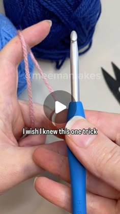 someone is knitting yarn with blue crochet hooks