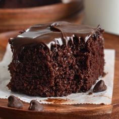 a piece of chocolate cake sitting on top of a wooden plate