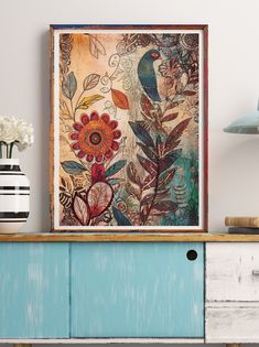 a painting on the wall above a blue cabinet with flowers and birds painted on it