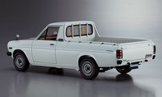 a white pick up truck parked on top of a gray floor