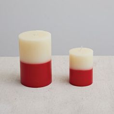 two red and white candles sitting next to each other