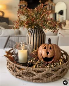 a pumpkin sitting in a basket next to a candle