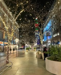 an empty city street is lit up with christmas lights