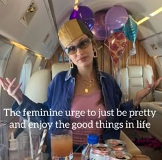 a woman sitting at a table in an airplane with balloons and confetti on her head