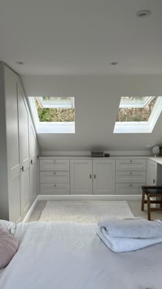 a bed sitting under two windows in a bedroom