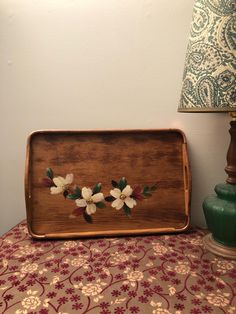 a wooden tray sitting on top of a table next to a lamp