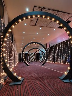 a large circular sculpture with lights on the sides and around it's edges in an empty room