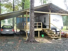 a car is parked in front of a mobile home with stairs leading up to the roof