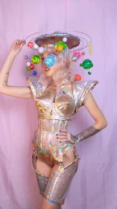 a woman in a silver bodysuit with lots of candy on her head