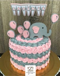 a pink and blue cake with an elephant on top