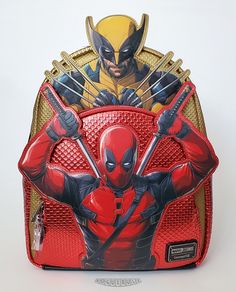 This is a new Loungefly Marvel "Deadpool & Wolverine" Layered Character mini backpack.  This amazing faux leather backpack features Deadpool and Wolverine character appliques, from the latest Deadpool movie, backed by metallic red and gold panels textured to simulate their superhero costumes.  The back and bottom panels and shoulder straps are made with a glittery black faux leather.  A fantastic Marvel themed backpack that is a little larger than most mini backpacks! - Faux leather construction - Deadpool and Wolverine appliques - Zipper closure with X-Men symbol pull - Front pouch with zipper closure and Deadpool symbol pull - Side pockets - Fabric lining with drop pocket - Sturdy chrome hardware - Adjustable padded shoulder straps Dimensions: 13"H x 11”W x 4.5”D This item is new...not p Men Symbol, Deadpool Symbol, Wolverine Character, Deadpool Movie, Superhero Costumes, Deadpool And Wolverine, Pouch With Zipper, Faux Leather Backpack, Mini Backpacks