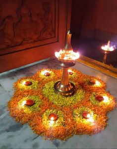 a small lamp is lit in the middle of a circular arrangement of flowers and candles