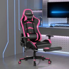 a pink and black office chair sitting in front of a computer monitor